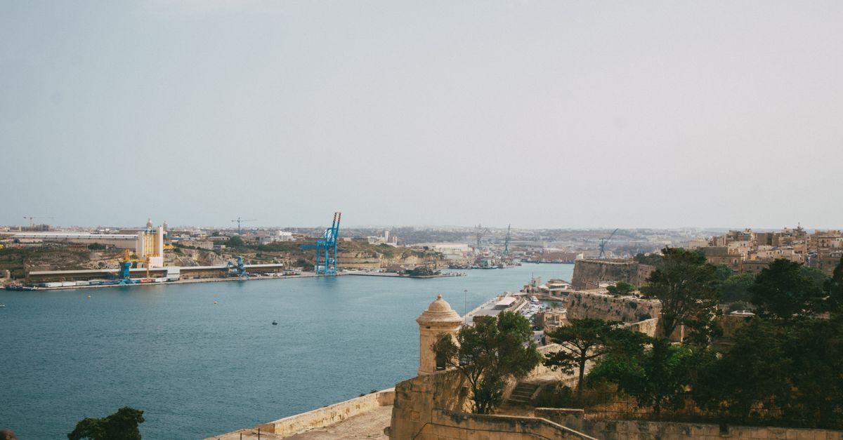 Digital nomad working on laptop overlooking Malta's historic Valletta harbor