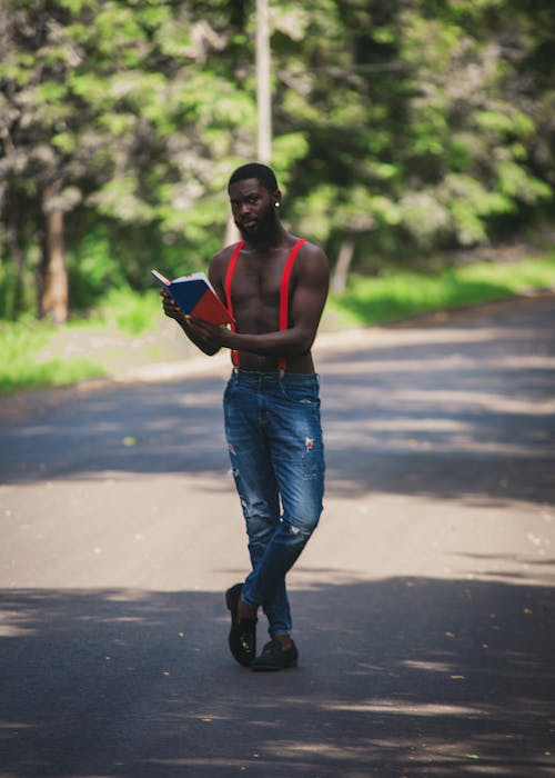 Bearded Man Holding a Book in the Middle of the Road