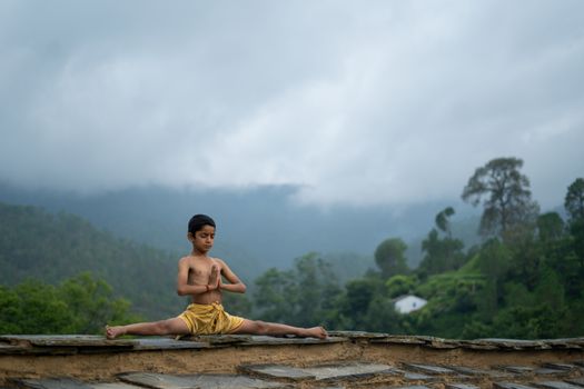 A child performs yoga in a serene forest setting, exemplifying peace and concentration.