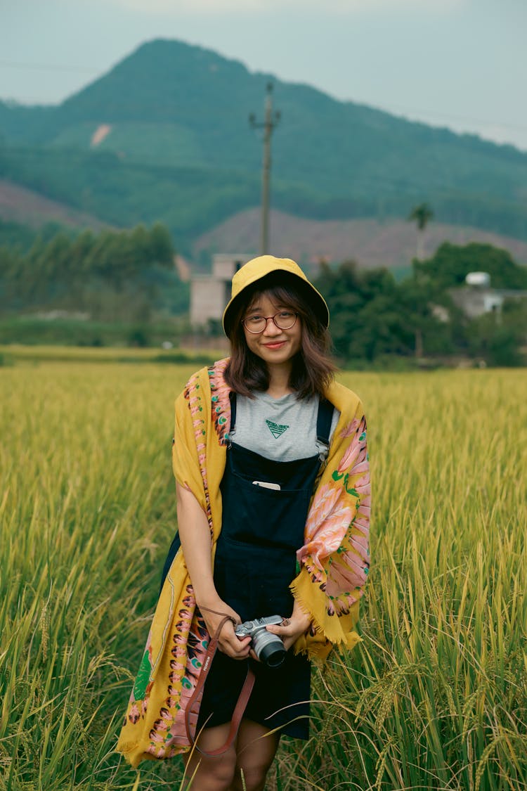 Woman In Jumper Standing On Rice Field