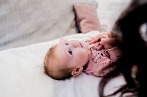 Free Cute Baby Lying on White Textile Stock Photo