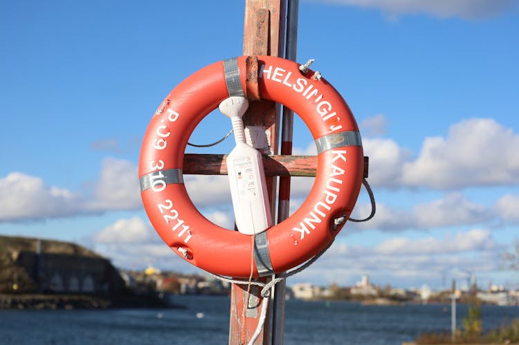 A Life Buoy Hanging On Wooden Post