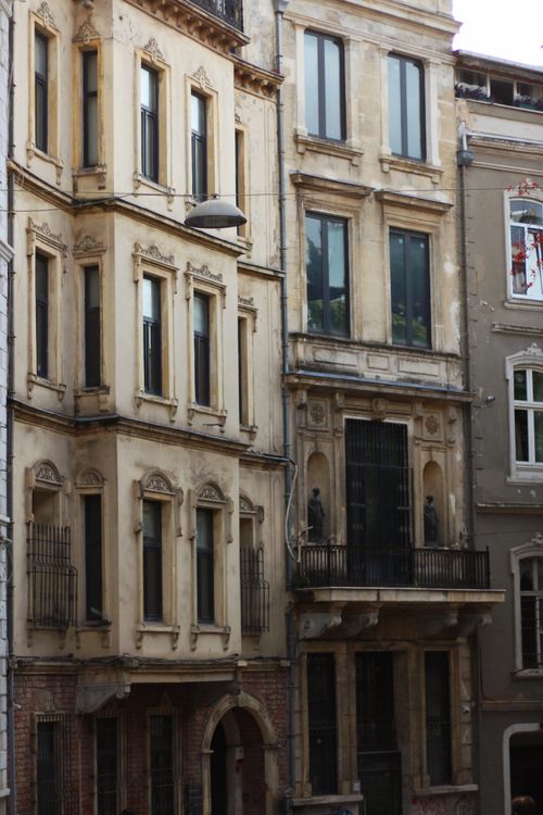 Free A detailed view of a charming vintage building facade with artistic balconies and windows. Stock Photo