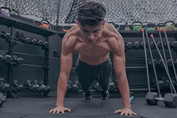 A Shirtless Man Exercising In The Gym