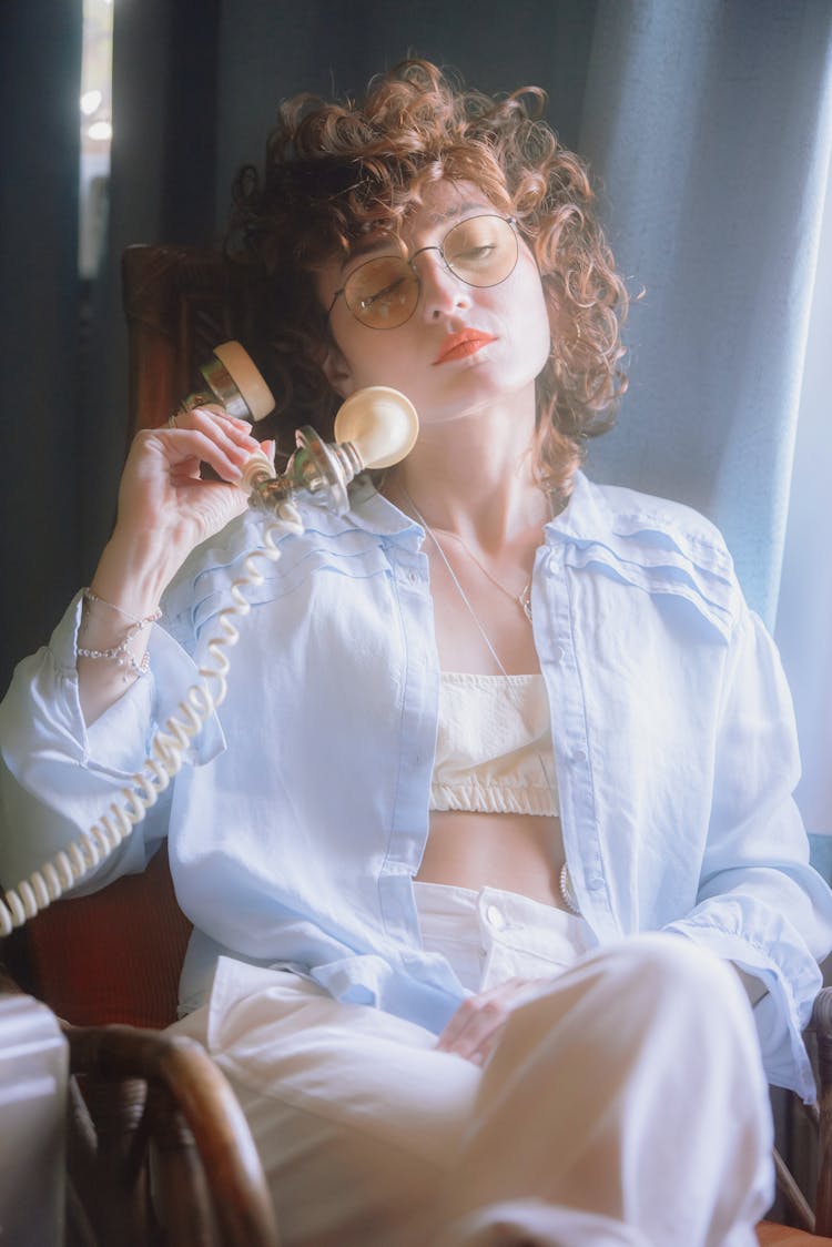 Woman Sitting In Chair And Holding A Phone In A Hand