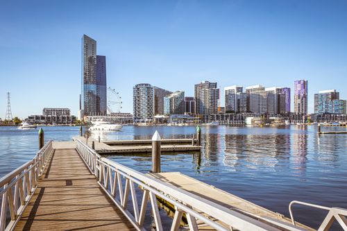 Free View of Melbourne's Docklands skyline with modern buildings and waterfront pier. Stock Photo