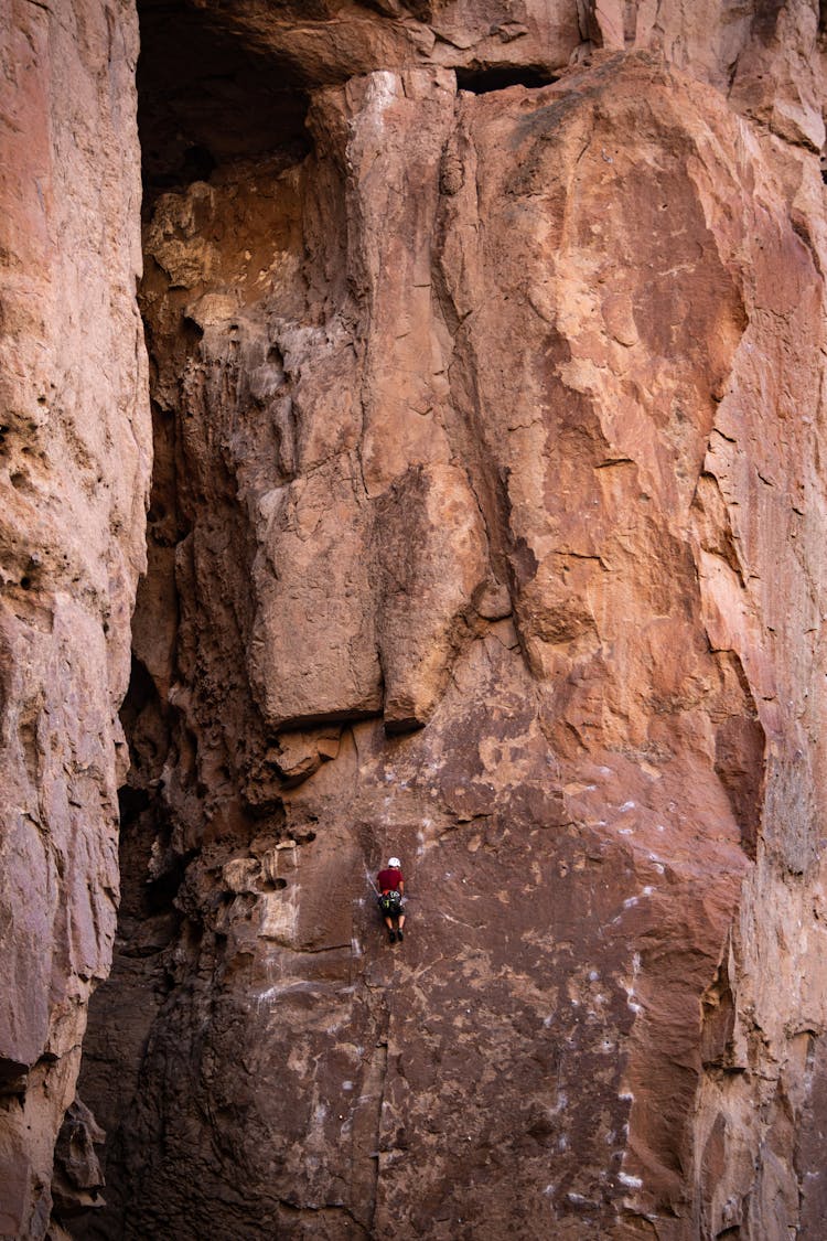 Person Climbing Vertical Rock Wall