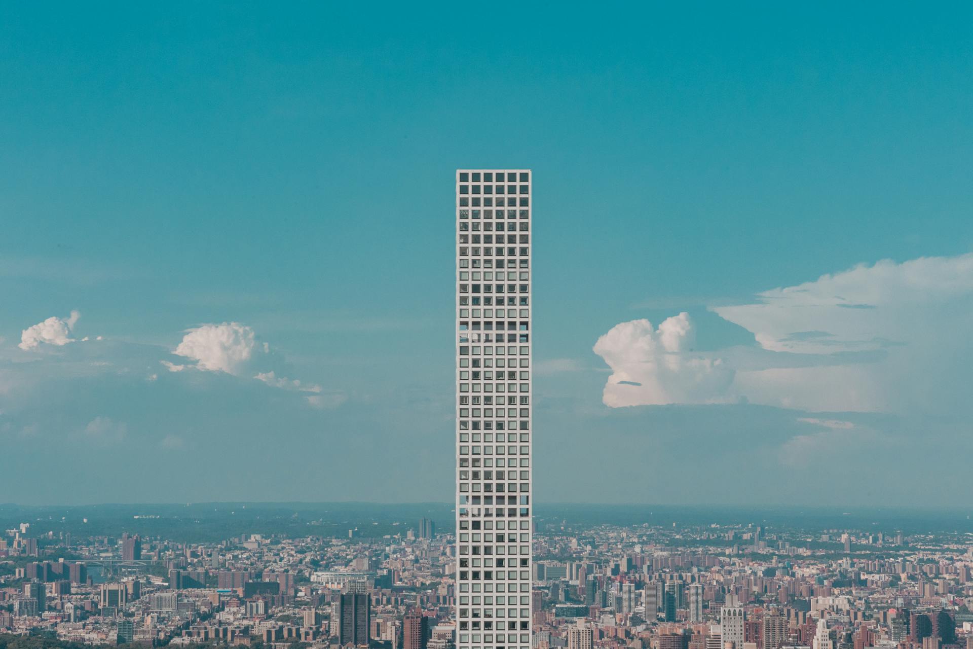 Aerial view of 432 Park Avenue towering over the urban landscape of New York City.