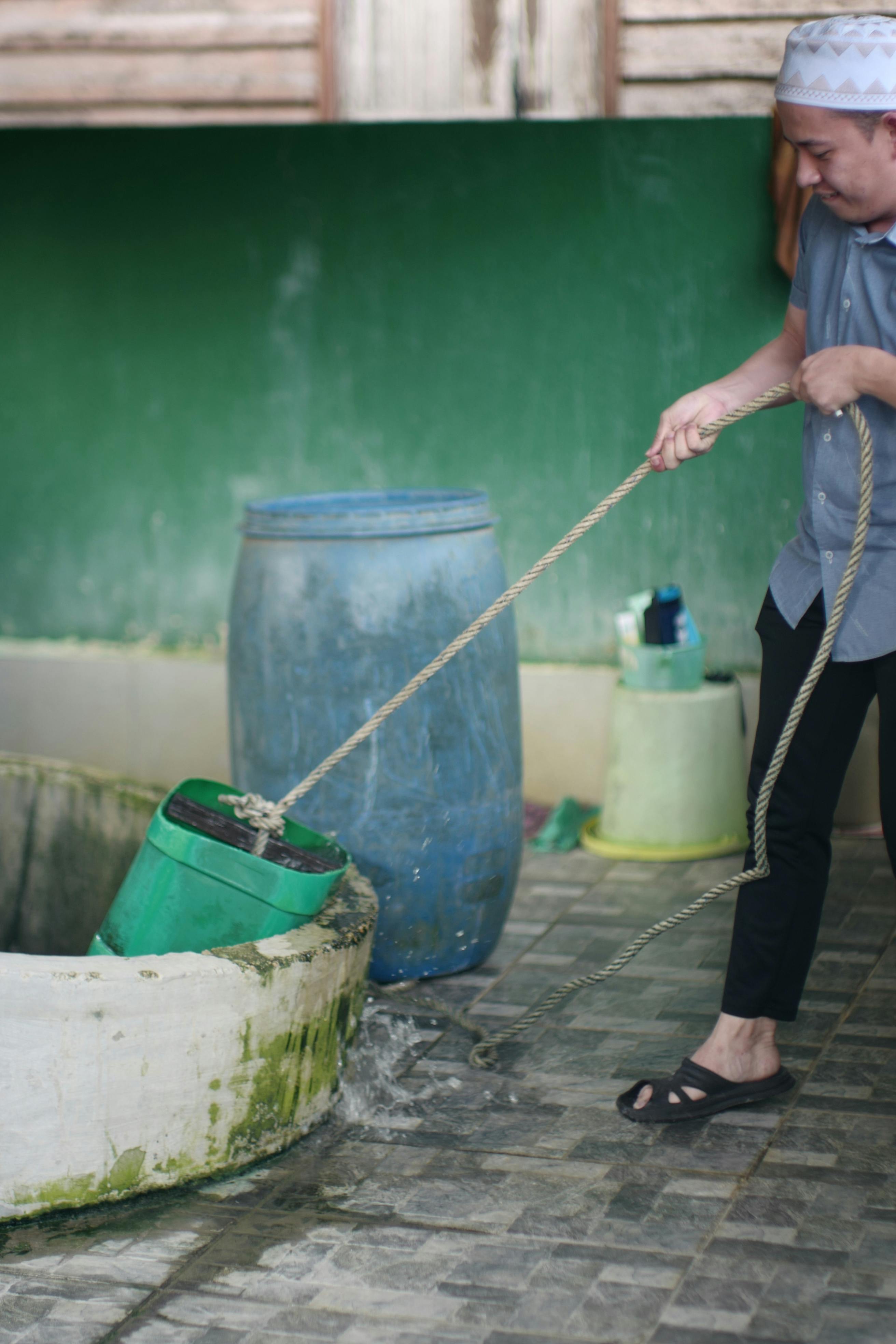 person with bucket on rope