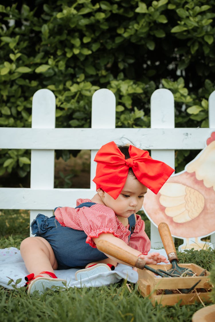 Cute Toddler Sitting On A Blanket On A Grass 