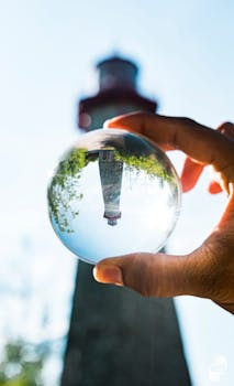 A creative shot of a Toronto lighthouse reflected in a crystal ball held by a hand.