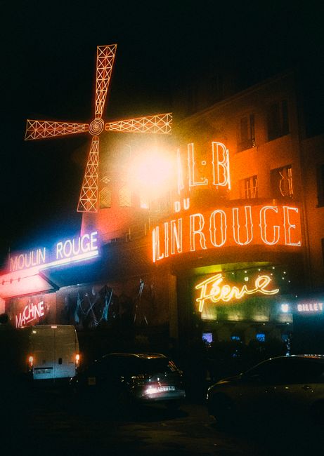 Capture of Moulin Rouge illuminated by neon signs at night in Paris, France.