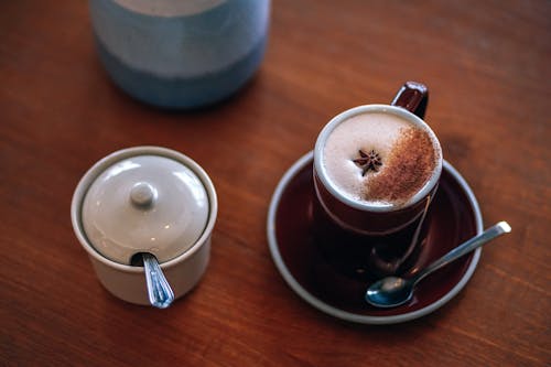 Mug of Latte Beside White Container