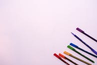 白色背景上排列着色彩鲜艳的笔，留有充足的版权空间