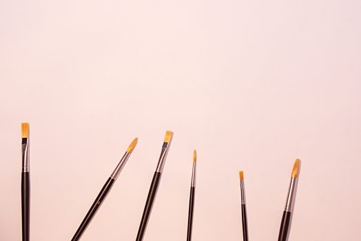 A variety of paintbrushes in different sizes against a clean white background, perfect for artistic themes.