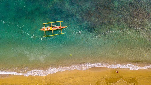 Yellow and Red Wooden Boat on Beach Shore