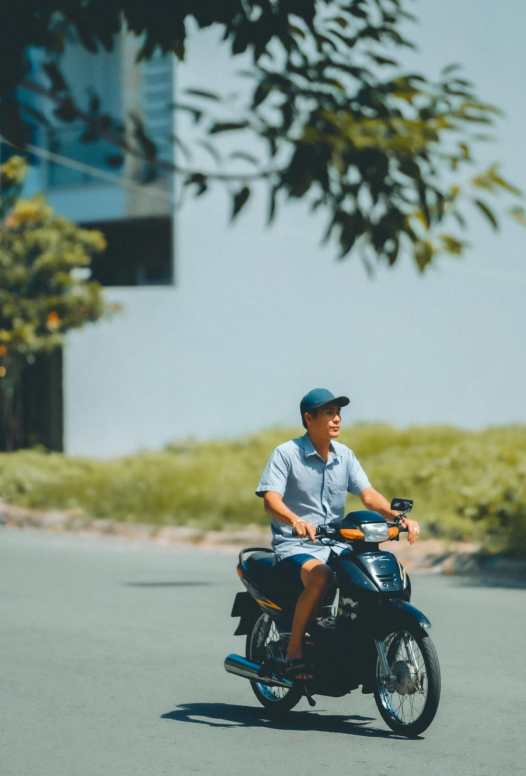 Free A man rides a motorcycle on a sunny day in an urban area. Stock Photo