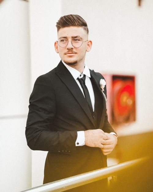 Free Stylish man wearing a black tuxedo and glasses, standing indoors in Aceh, Indonesia. Stock Photo