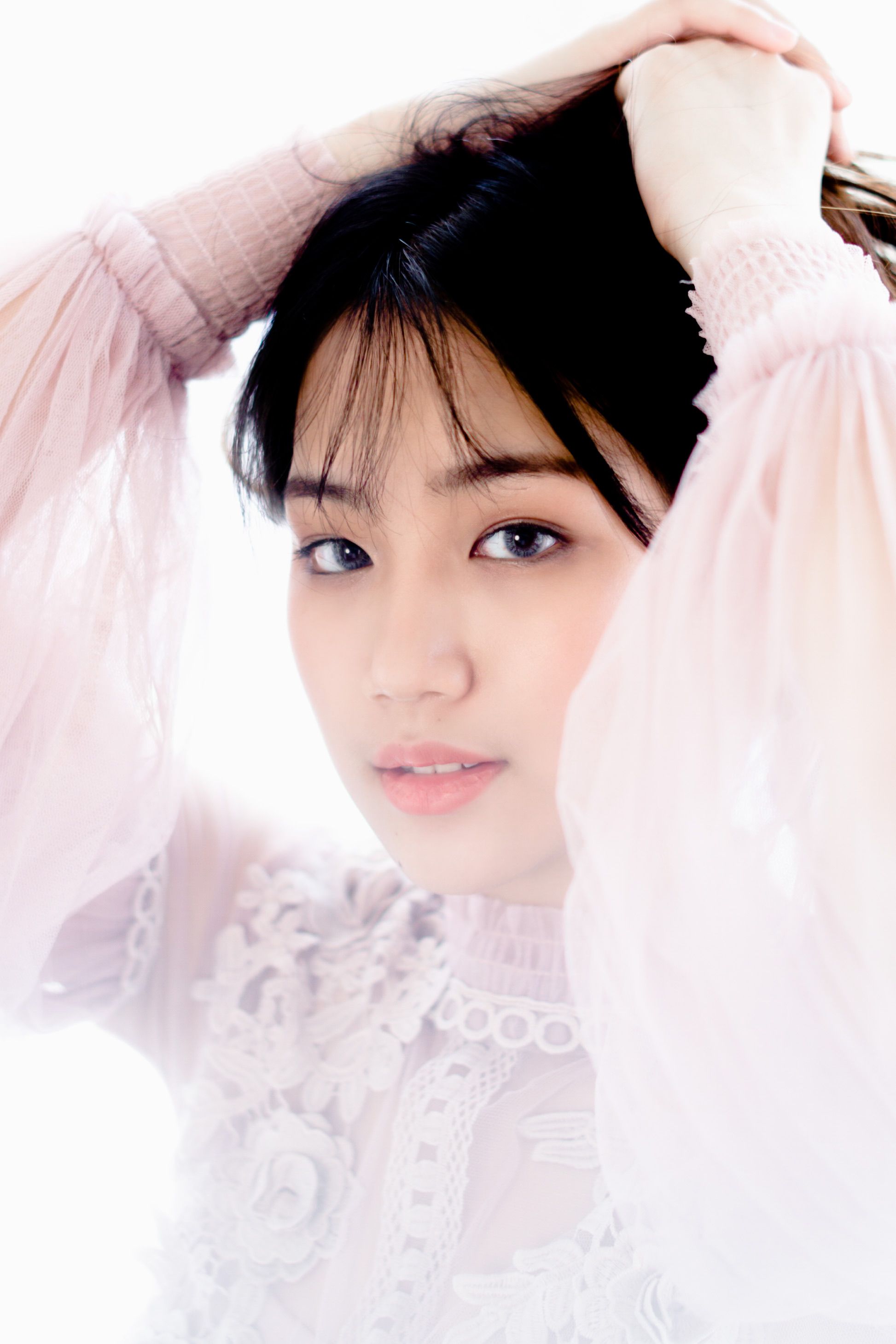 An elegant portrait of a woman posing indoors with a soft expression.