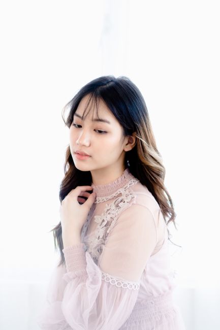 Elegant portrait of a young woman in a delicate lace dress, exuding calm and contemplation.