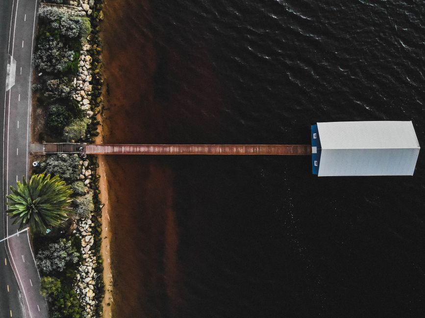 Stunning aerial photo of a wooden jetty stretching into a serene body of water in Crawley, WA.