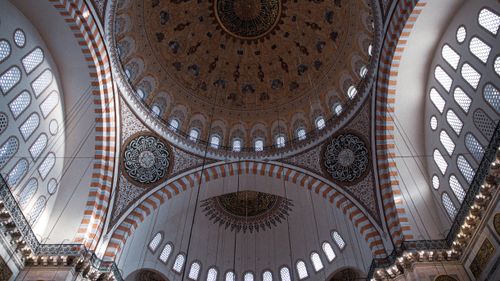 Free Beautifully detailed dome inside a grand mosque with arches and calligraphy. Stock Photo