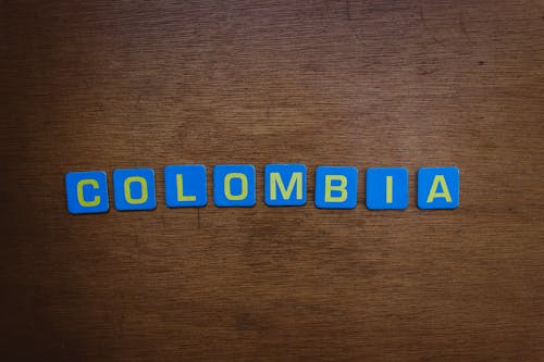 Blue and Yellow Scrabble Tiles on Wooden Surface