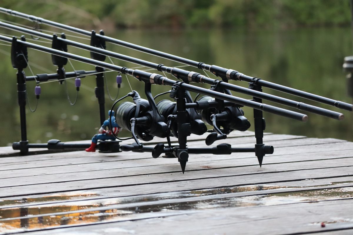 Fishing rods set up along a pier on a tranquil river