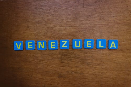 Blue and Yellow Scrabble Tiles on Wooden Surface