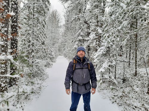 Backpacker Standing on the Country Road in the Forest 