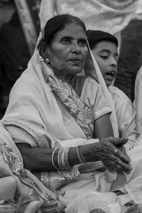 Free Elderly Indian woman in traditional clothing, praying during a cultural festival, captured in black and white. Stock Photo