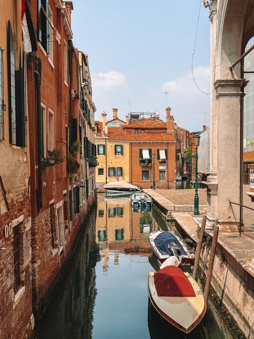 Free Peaceful Venetian canal scene with colorful buildings and gondolas. Stock Photo