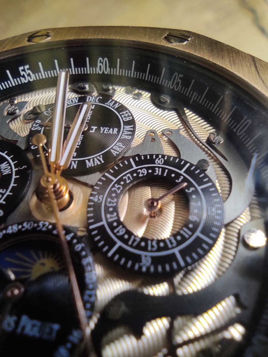 Macro de um calendário perpétuo Audemars Piguet esqueletizado, com pontes guilhochadas, rubis e discos de mês e data à mostra