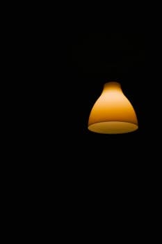 Simple yellow lamp against a dark backdrop, perfect for wallpaper or design projects.