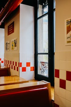 Elegant vintage diner interior featuring tiled walls, wooden tables, and glass doors capturing a nostalgic ambiance.