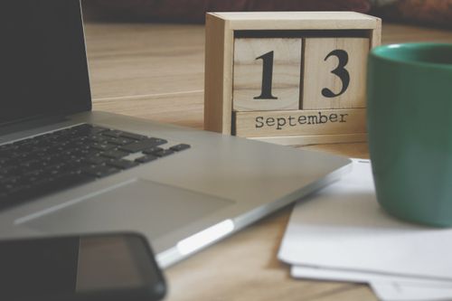 Free Modern home office setup with a laptop, smartphone, and calendar displaying September 13. Stock Photo