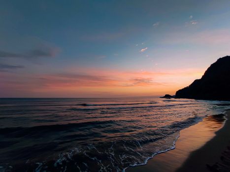 Beautiful ocean scene at twilight with colorful sunset reflecting on calm waters.