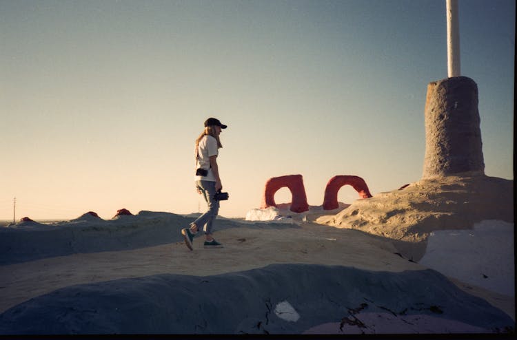 A Person Walking On Brown Sand