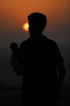 A dramatic silhouette of a man with a camera captured against a beautiful Lebanese sunset.