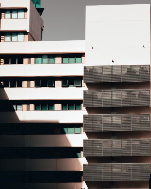 Free A contemporary building featuring a geometric facade and reflective windows under sunlight. Stock Photo