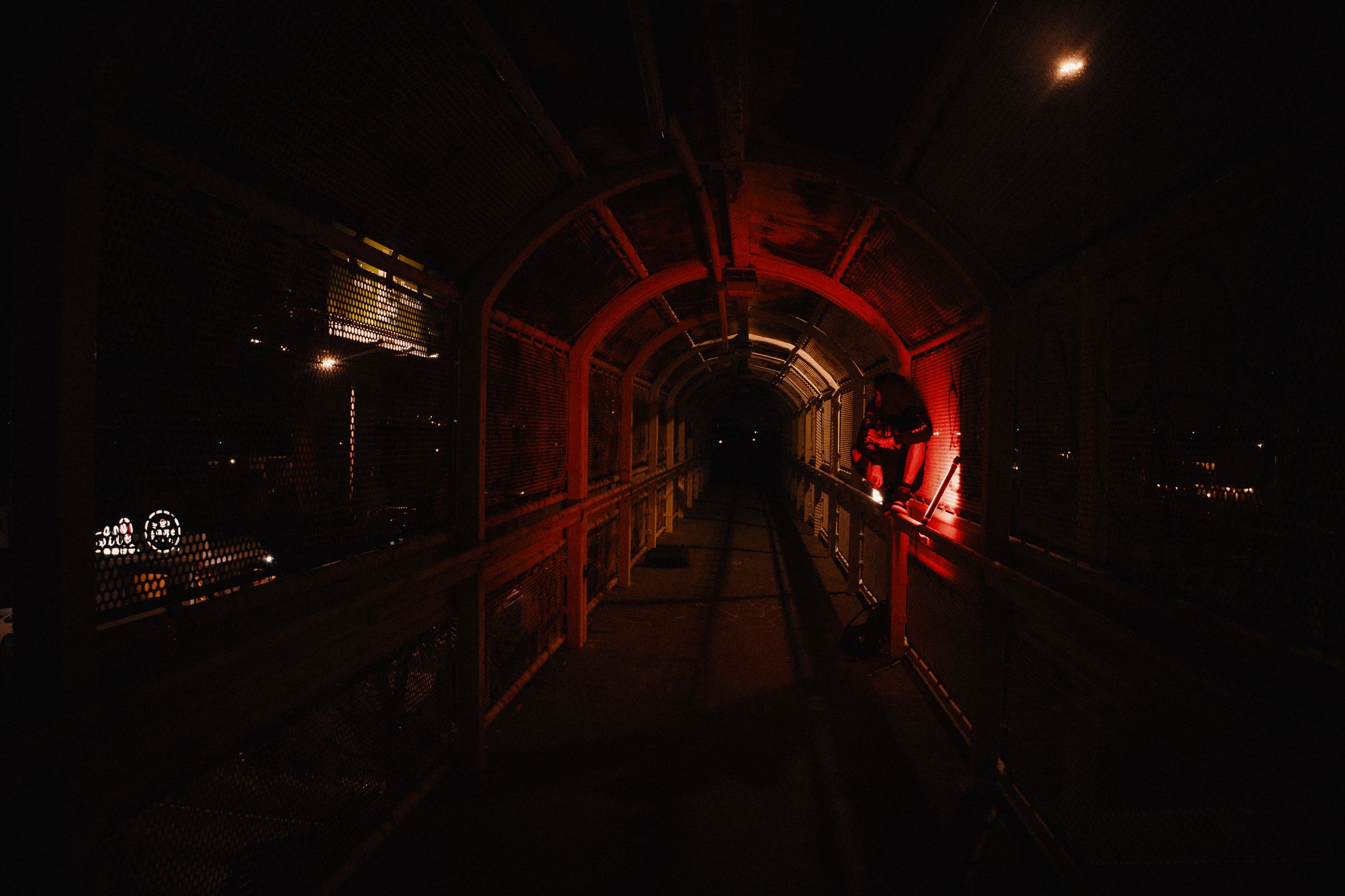 Long underground corridor washed in red emergency lighting