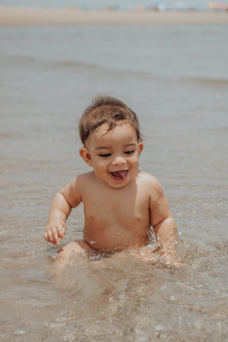 Happy Baby Splashing In Sea