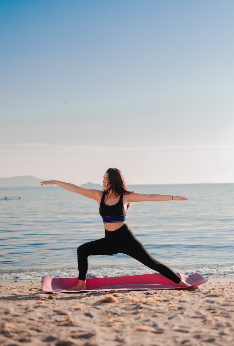 Woman Practicing Yoga On Beach