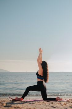 A woman in sportswear meditating on a peaceful beach during sunrise. Ideal for fitness and wellness themes.