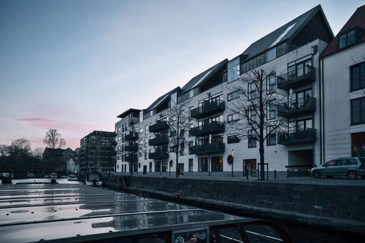 Urban scene capturing modern apartments along a canal in Copenhagen during twilight.