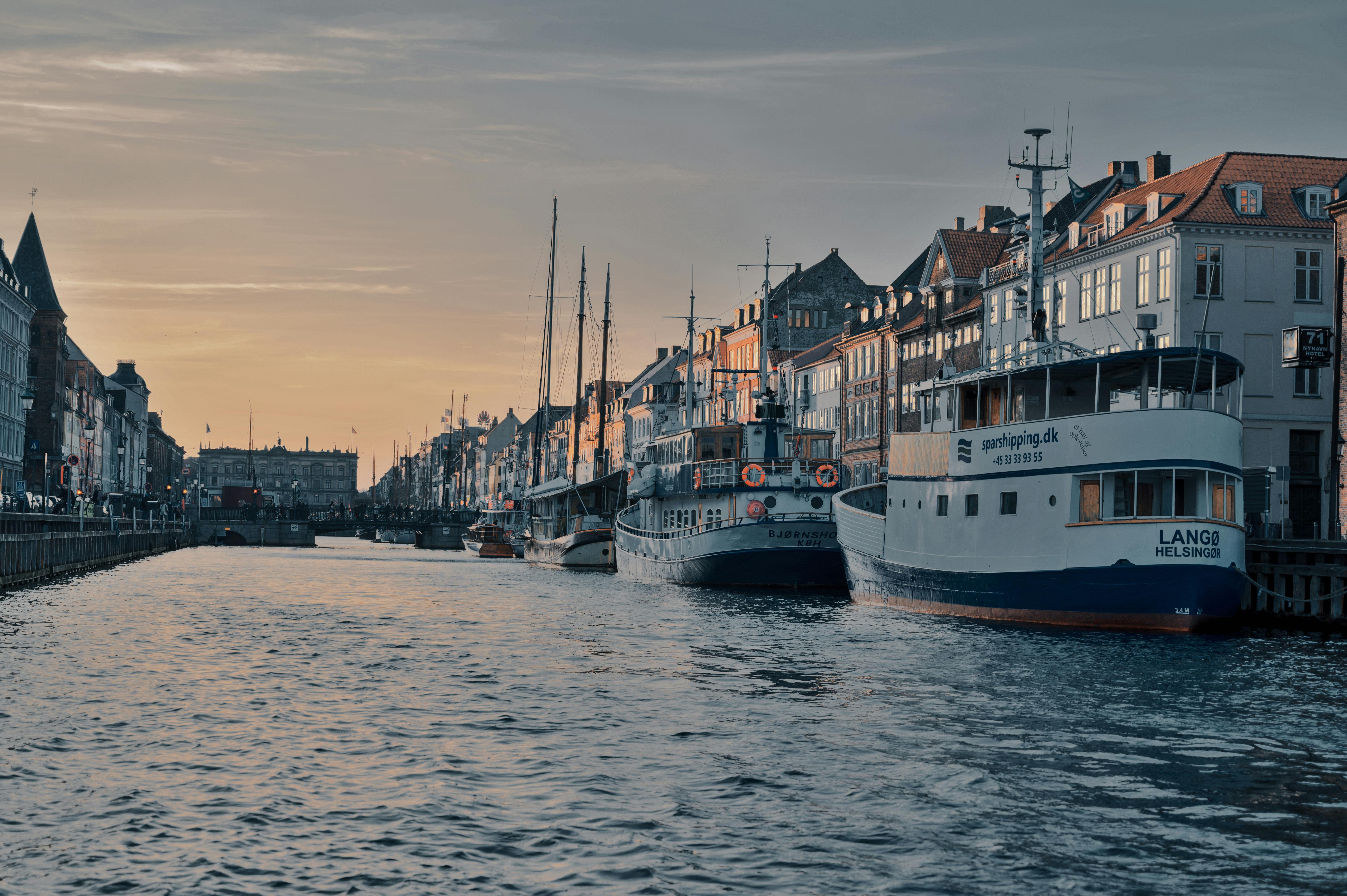 Tranquil view of Nyhavn Canal with boats docked along historic buildings in Copenhagen, Denmark.