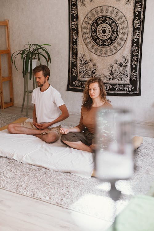 Man and Woman Meditating in the Room