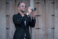 一位时尚男子戴着墨镜在城市中拍照