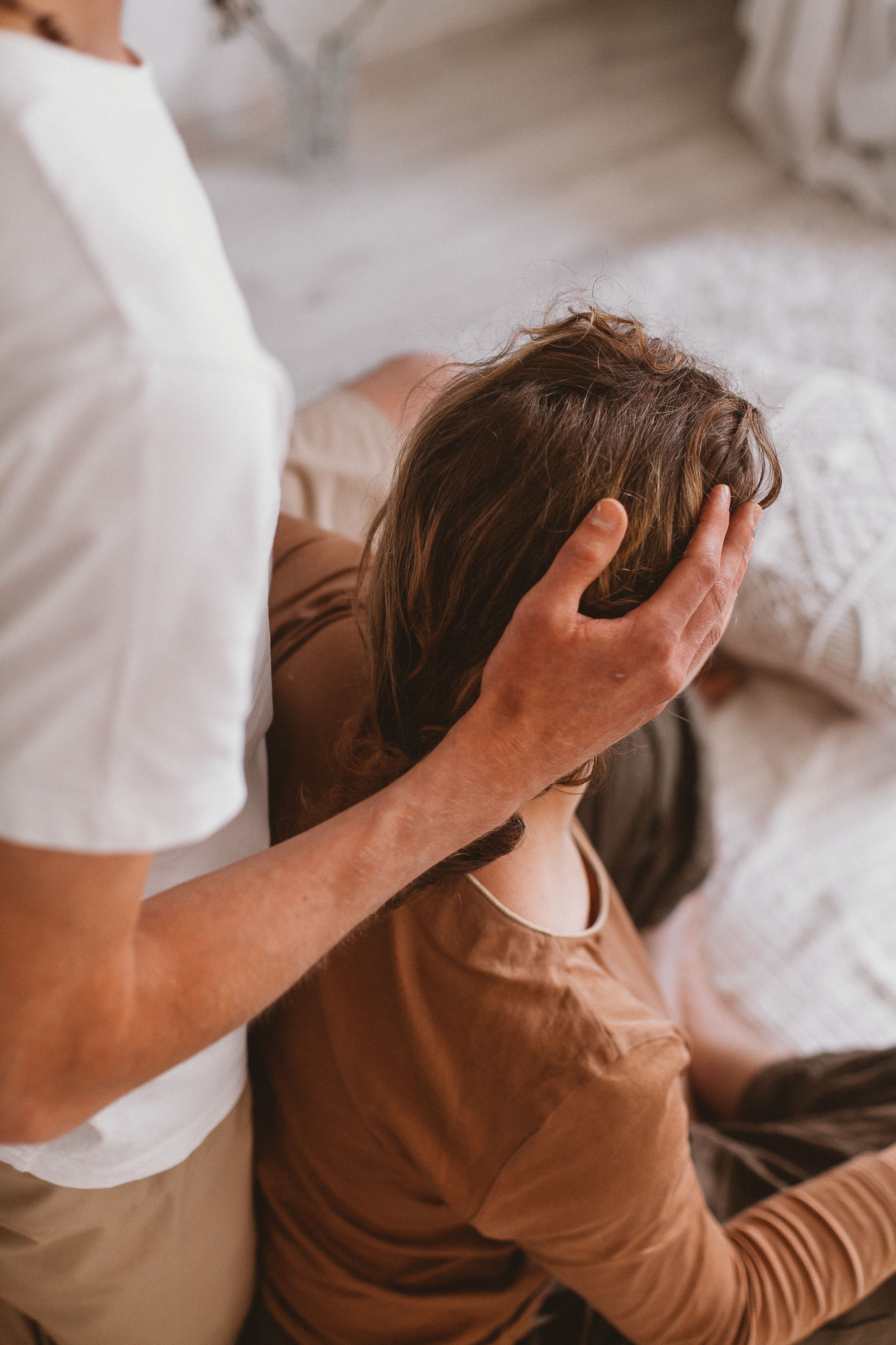 Man Holding Hand on Woman Head