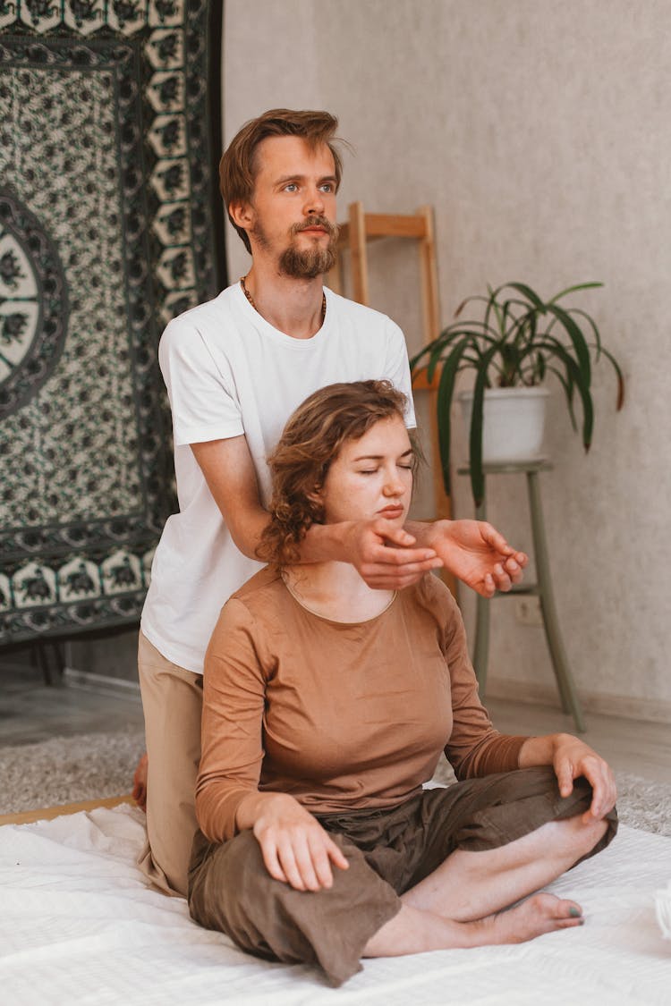 Man Holding Arms On Sitting Woman 